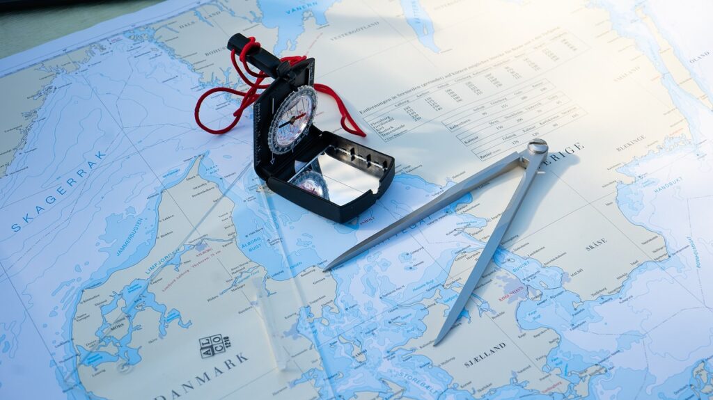 Der Ausschnitt einer großformatigen Karte, auf der Zirkel und Kompass liegen